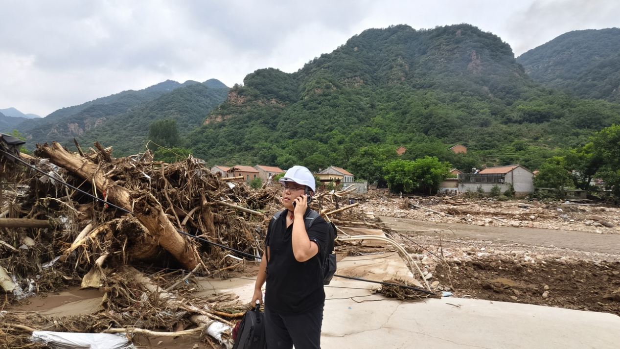 工作人员在兴隆县救灾现场使用“天通北斗融合终端”通话。王丙超摄影